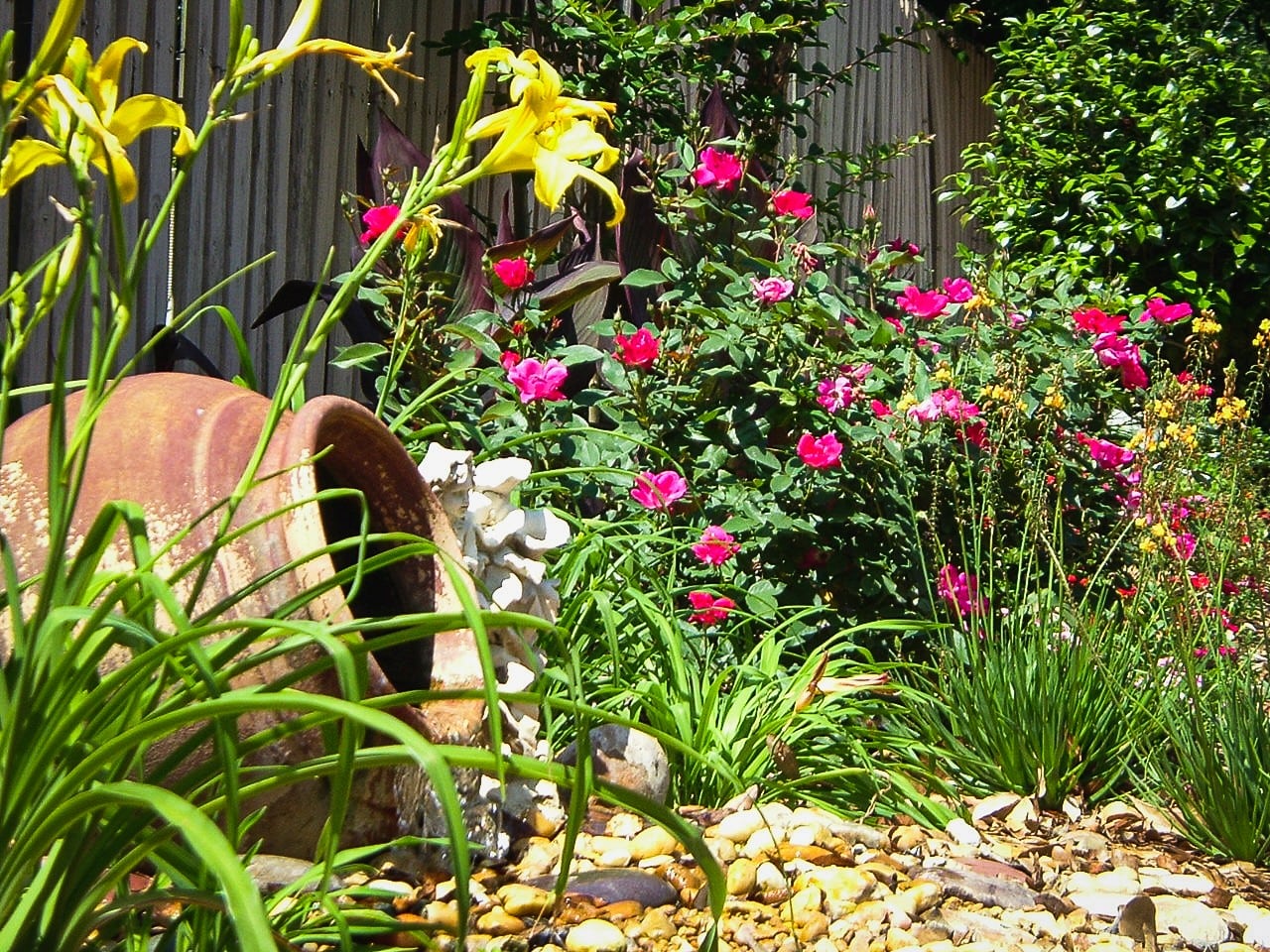 garden landscaping with a large pot and colorful flowers